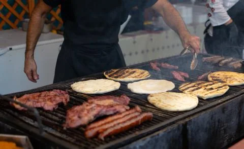 Chef preparing meat on the grill, during outdoor outside food festival Foto stock