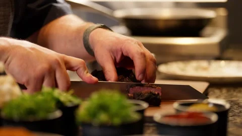 Chef preparing medium rare steak prime rib restaurant kitchen cutting with knife Stockbeeldmateriaal 246703799