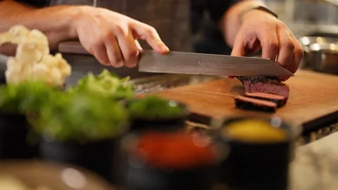 Chef preparing medium rare steak prime rib restaurant kitchen cutting with knife Видео 246703801