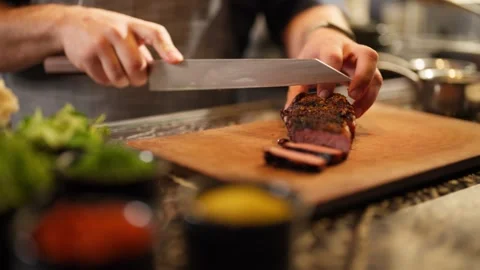 Chef preparing medium rare steak prime rib restaurant kitchen cutting with knife Stock Footage 246703803