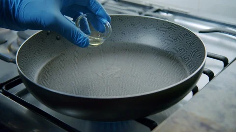 Chef Preparing a Pan With Vegetable Oil Olive Before Cooking Stock Footage 128697718