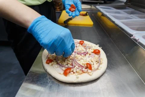 Chef preparing pizza on metal table, closeup. Fotos de archivo