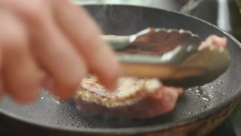 Chef preparing pork chop in a frying pan. Stock Footage 165622337