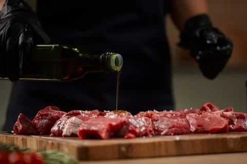 Chef preparing raw beef with olive oil 写真素材