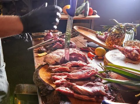 Chef Preparing Raw Meat with Knife and Gloves Stock Photos