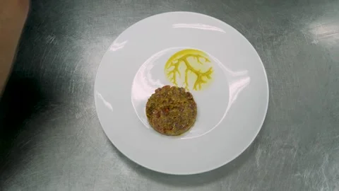 Chef preparing raw meat tartare in sauce, man arranging the tartare in a plate a Stock Footage 262796547