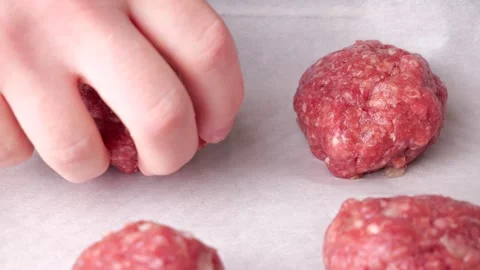 Chef preparing raw meatballs on baking paper in slow motion Stock Footage 305865162