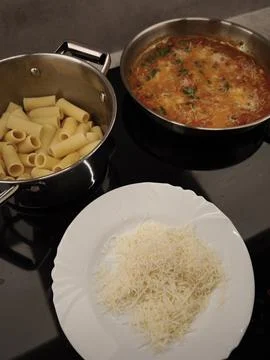 Chef preparing rigatoni pasta with tomato sauce and grated cheese in prague Stock Photos