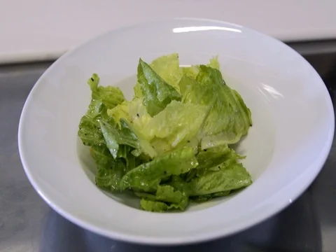 Chef preparing a salad. Spread tomatoes, onion falls.Slow motion Stock Footage 76055964