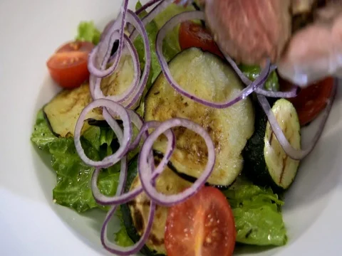 Chef preparing a salad. Spread tomatoes, onion falls.Slow motion Video stock 76056029