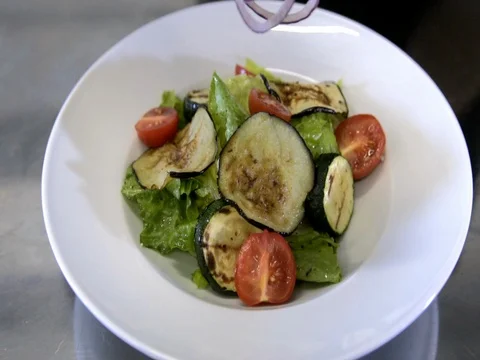 Chef preparing a salad. Spread tomatoes, onion falls.Slow motion Stock Footage 76056075