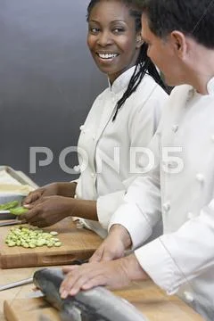 Chef Preparing Salmon By Colleague Stock Photos