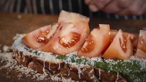Chef preparing a sandwich with pesto, tomatoes and cheese. Slow motion 50fps. Stock Footage 304784610