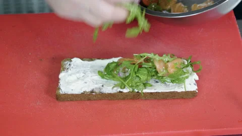 Chef preparing sandwich with rye bread, salmon, cheese, vegetables and herbs. 4K 库存影片 97662780