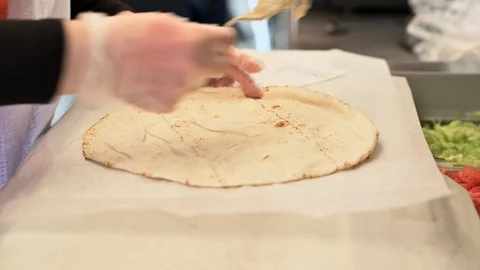 Chef preparing shawarma. Putting lettuce and tomatoes on pita bread Stock Footage 114184449