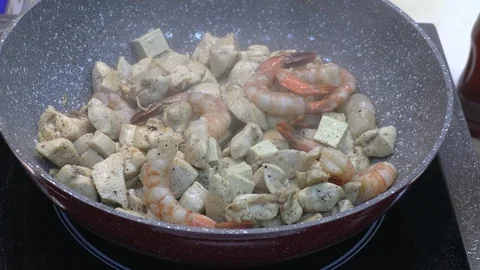 Chef preparing shrimp, chicken, garlic and onion Asian dish in wok  Stock Footage 86262395