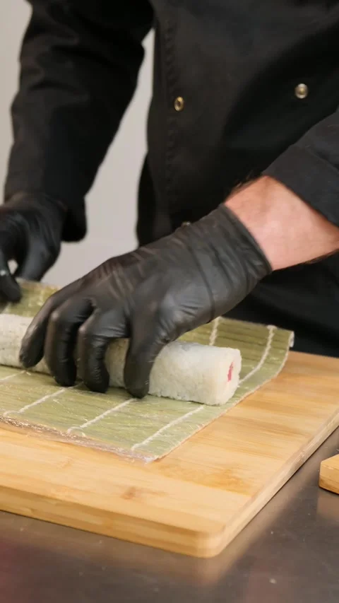 The chef is preparing sushi. Makes a roll with a bamboo mat Stock Footage 262581809