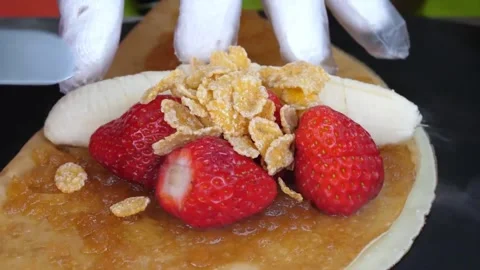Chef Preparing Sweet Fruit Crepe with Fresh Strawberries and Banana Slices Vídeo Stock 343588236