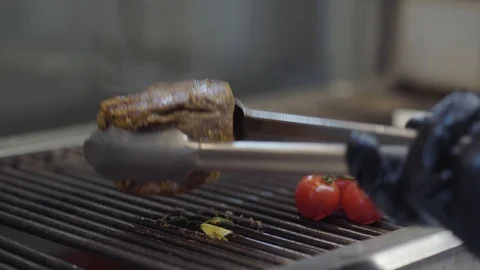 Chef preparing tasty meat on the grill, turning it with tongs close-up. Red Stock Footage 109213015