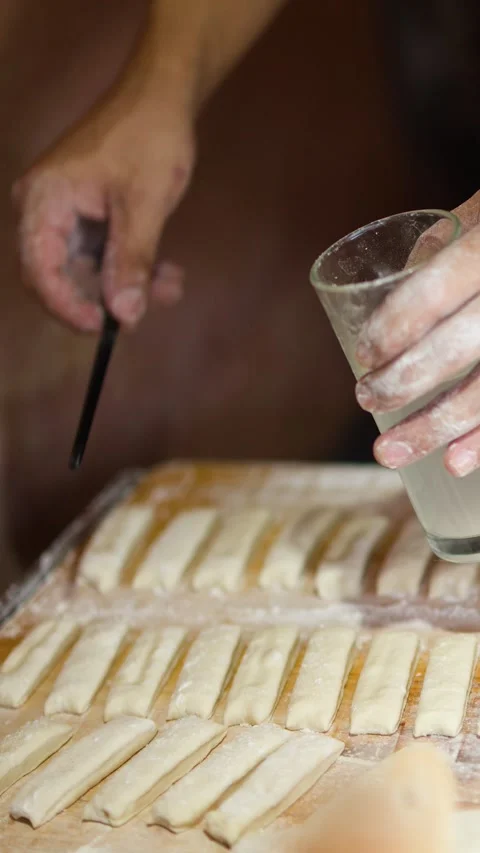 Chef Preparing Traditional Dough Strips with Water and Stick Tool Stock Footage 340192343