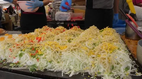 Chef preparing traditional Hiroshima style okonomiyaki on a massive flat iron gr Stock-Footage 347688885