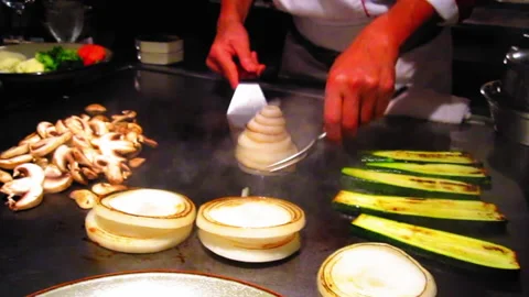 Chef Preparing Vegetables On Flat Griddle In Kitchen At Restaurant - Los Stock Footage 236964022