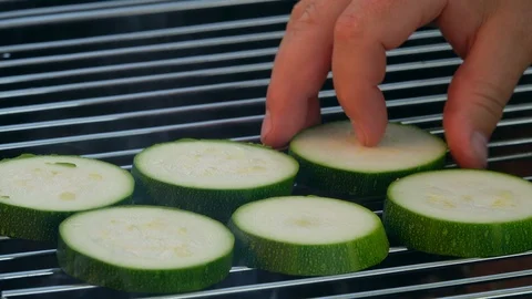 The chef preparing vegetarian barbecue, putting sliced raw zucchini on grill. 4K 動画素材 108617133