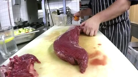 Chef is preparing a whole red fillet mignon, at a restaurant kitchen Stock Footage 57370985