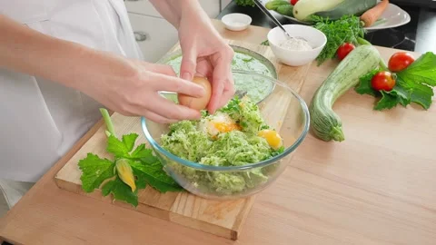 The chef is preparing zucchini. Beat eggs into a glass bowl with grated zucchini Stock Footage 270149889