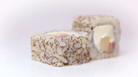 Chef presentation sushi rolls with poppy seeds Nomi Maki rotating on white Stock Footage 80565679