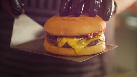 Chef Presenting a Cheeseburger with Bacon on a Spatula Stock Footage 95187215