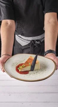 Chef presenting plate of New York cheesecake or classic cheesecake with fresh Stock Photos