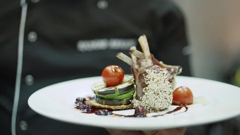 Chef presents his dish chicken legs with tomato and sesame seeds Stock Footage 126096500