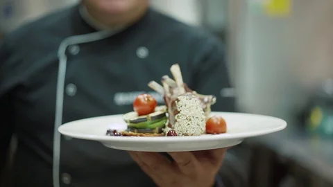 Chef presents his dish chicken legs with tomato and sesame seeds Stock Footage 128242575