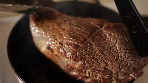 Chef presses the roast beef with a spatula and tongs into the pan for even Stock Footage 296241953