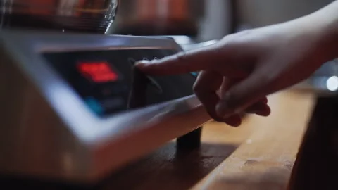 Chef pressing power button on professional food steamer Stockbeeldmateriaal 323098727