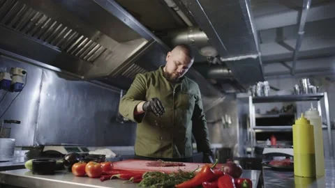 A chef in the process of preparing delicious steak in the kitchen of restaurant Stock Footage 231053753
