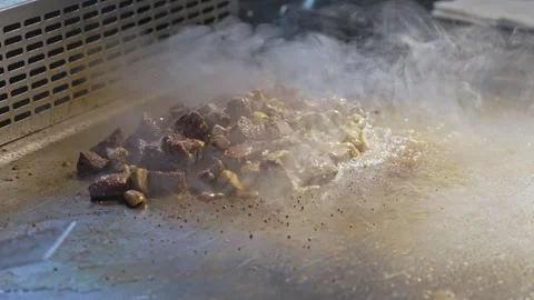 The chef in the professional kitchen of the restaurant roasts juicy meat and Stock Footage 278580755