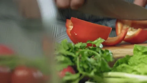 Chef professionally cutts red sweet pepper with chef's knife on cutting board Stock Footage 76960316