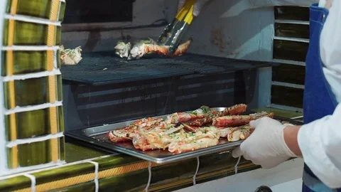 The chef pulls out of red crabs from the oven grill. Delicious tentacles of the Stock Footage 77271158