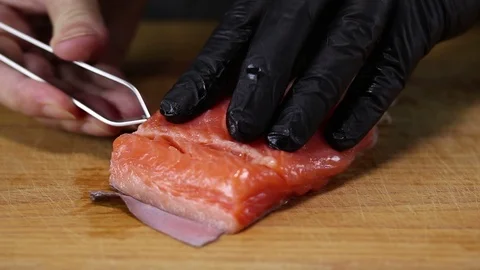 Chef pulls tweezers bones from trout fillet Stock Footage 122995212