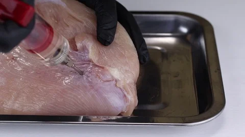 A chef pumps a solution of nitrite salt into a turkey pulp Stock Footage 121630442