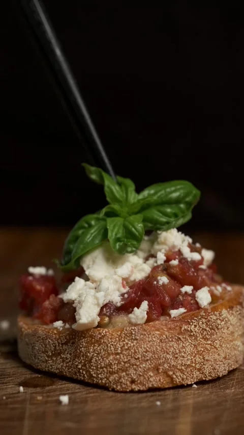 Chef put a basil leaf on a top of bruschetta by tweezers. Ready to eat Stock Footage 283631992