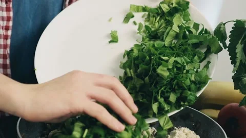 Chef put basil on a pot with fried mushrooms and feta cheese. Making delicious Stock Footage 136182135
