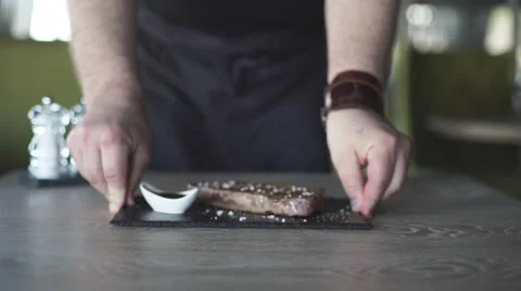 Chef put beef steak on a table for customer in a restaurant Stock Footage 63446501