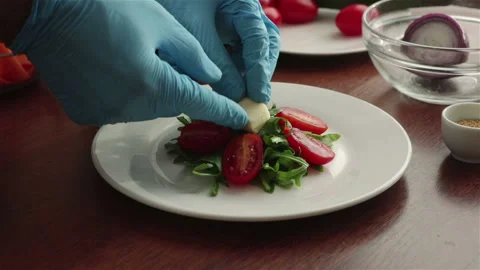 Chef put diced cheese on fresh salad with arugula leaves cherry tomatoes halves Stock Footage 106874094