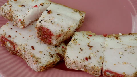 Chef put pieces raw pork lard sprinkled with with spices and salt on pink plate. Stock Footage 234070487