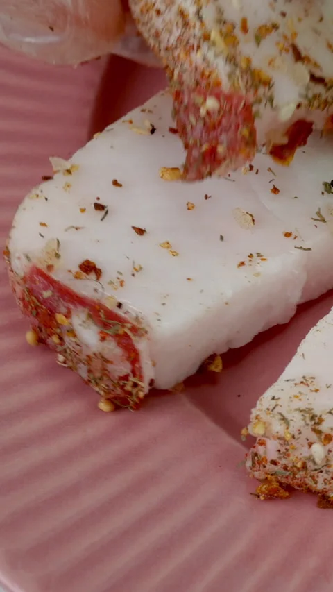 Chef put pieces raw pork lard sprinkled with with spices and salt on pink plate. Stock Footage 234533489
