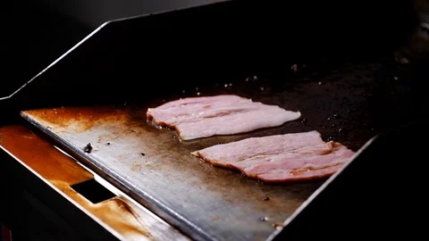 Chef put raw bacon fast food on a hot grill 4k Stock Footage 94263780