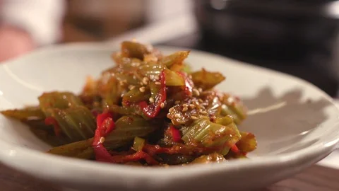 Chef put ready-made salad from edible burdock on the table Stock Footage 119189764